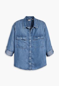Camicia in denim con colletto classico, chiusura a bottoni, due tasche sul petto, maniche arrotolate e un lavaggio azzurro chiaro con leggere sfumature.