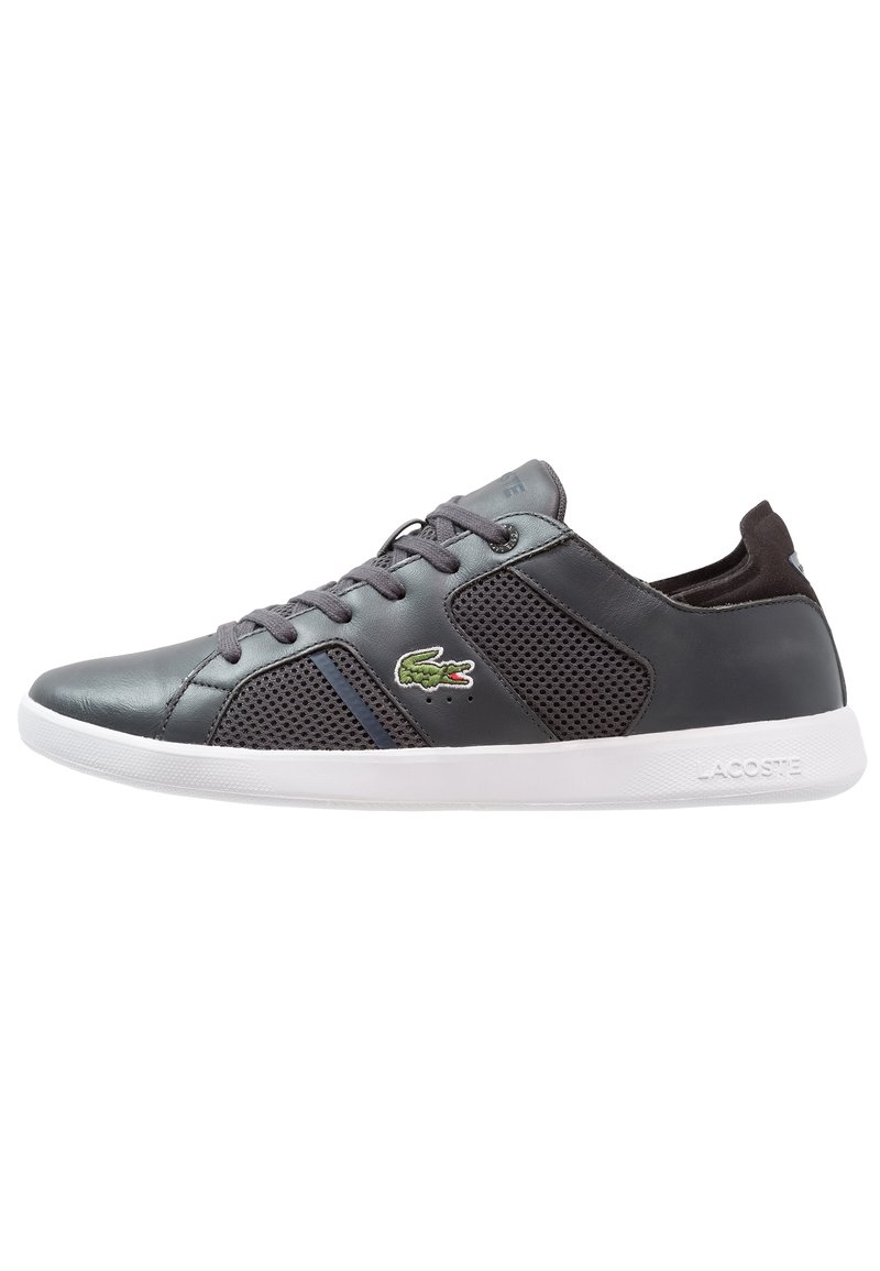 Baskets en cuir gris et mesh avec semelle blanche, dotées d'une fermeture à lacets et du logo Lacoste vert. Détails comprenant un col et une languette rembourrés.