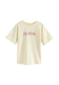 Kermanvärinen puuvillapaita, jossa on lyhyet hihat ja pyöreä kaula-aukko. Edessä on pinkki "Def Leppard" -grafiikkalogo.