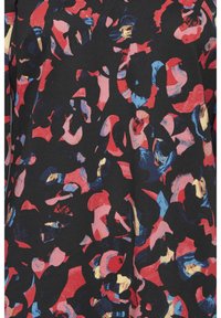 Schwarzer Stoff mit einem abstrakten Muster aus roten, blauen und rosa Formen, das eine strukturierte Optik mit variierender Farbintensität erzeugt.