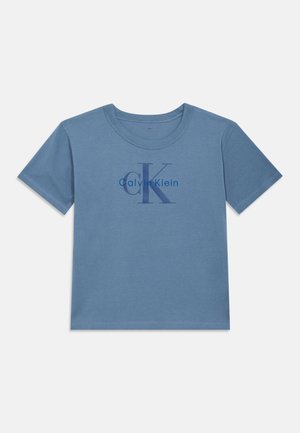 Camiseta de algodón azul con mangas cortas y cuello redondo, que presenta un logo en azul oscuro de "Calvin Klein" y un gráfico de "CK" en la parte delantera.
