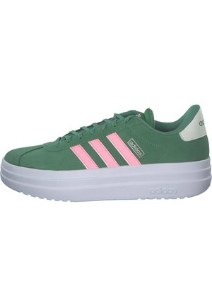 Sneakers in suede verde con design a tre strisce rosa, suola bianca e colletto imbottito, caratterizzati da una superficie testurizzata e punta rinforzata.