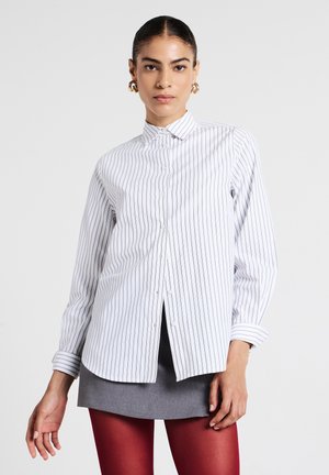 Camicia bianca con bottoni, a righe verticali grigie, maniche lunghe e polsini con risvolto. Presenta un colletto classico e un orlo dritto.