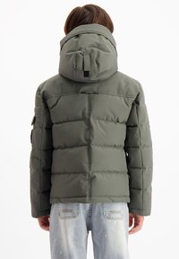 Olijf groene pufferjack met een capuchon, gequilt patroon en ritszakken. Kenmerken zijn een zachte textuur en een verstelbare capuchon.