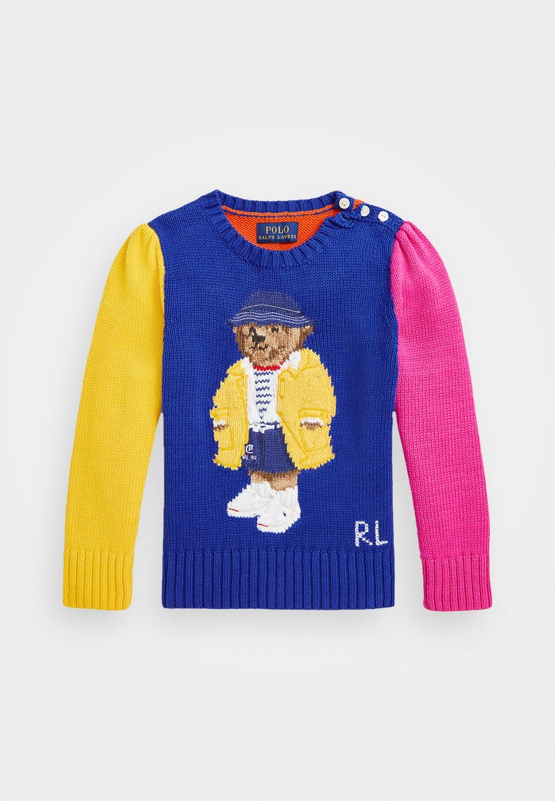 Suéter de punto multicolor con un cuerpo azul, manga izquierda amarilla, manga derecha rosa, que presenta un oso bordado con un abrigo amarillo.