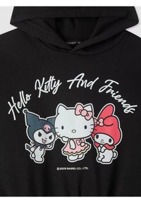 Felpa nera con cappuccio che presenta una stampa grafica di Hello Kitty e dei suoi amici. I personaggi sono colorati, con dettagli notevoli come un fiocco e una gonna rosa.