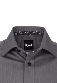 Camicia grigia con bottoni, realizzata in un tessuto testurizzato, con un motivo floreale all'interno del colletto. Bottoni neri e un'etichetta che indica "Kauf."