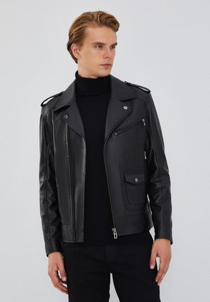 Black leather motorcycle jacket with zippered front, side pockets, and shoulder epaulettes. Smooth texture and fitted design.