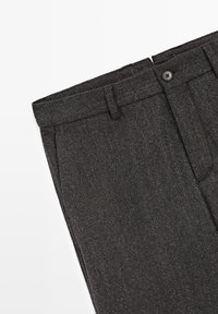 Ciemnoszare, dopasowane spodnie z zapięciem na guziki, szlufkami na pasek oraz bocznymi kieszeniami na teksturowanej tkaninie.