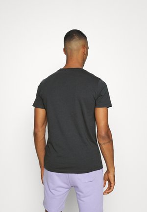 Dark gray cotton t-shirt with short sleeves and a crew neckline, shown from the back, paired with purple shorts.