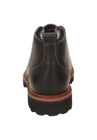 Stivale alla caviglia in pelle nera con una finitura texturizzata, suola marrone a contrasto e una lieve accentuazione blu. Dettagli cuciti intorno al tallone.
