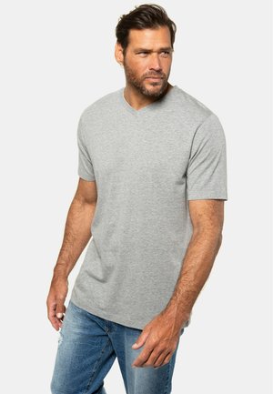 T-shirt grigio a maniche corte con scollo a V realizzato in morbido cotone, abbinato a jeans chiari strappati. Design semplice senza pattern.