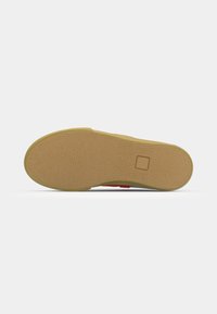 Shoe sole with a textured pattern, made of rubber, in a tan color. Features a square logo imprint and rounded edges for grip.