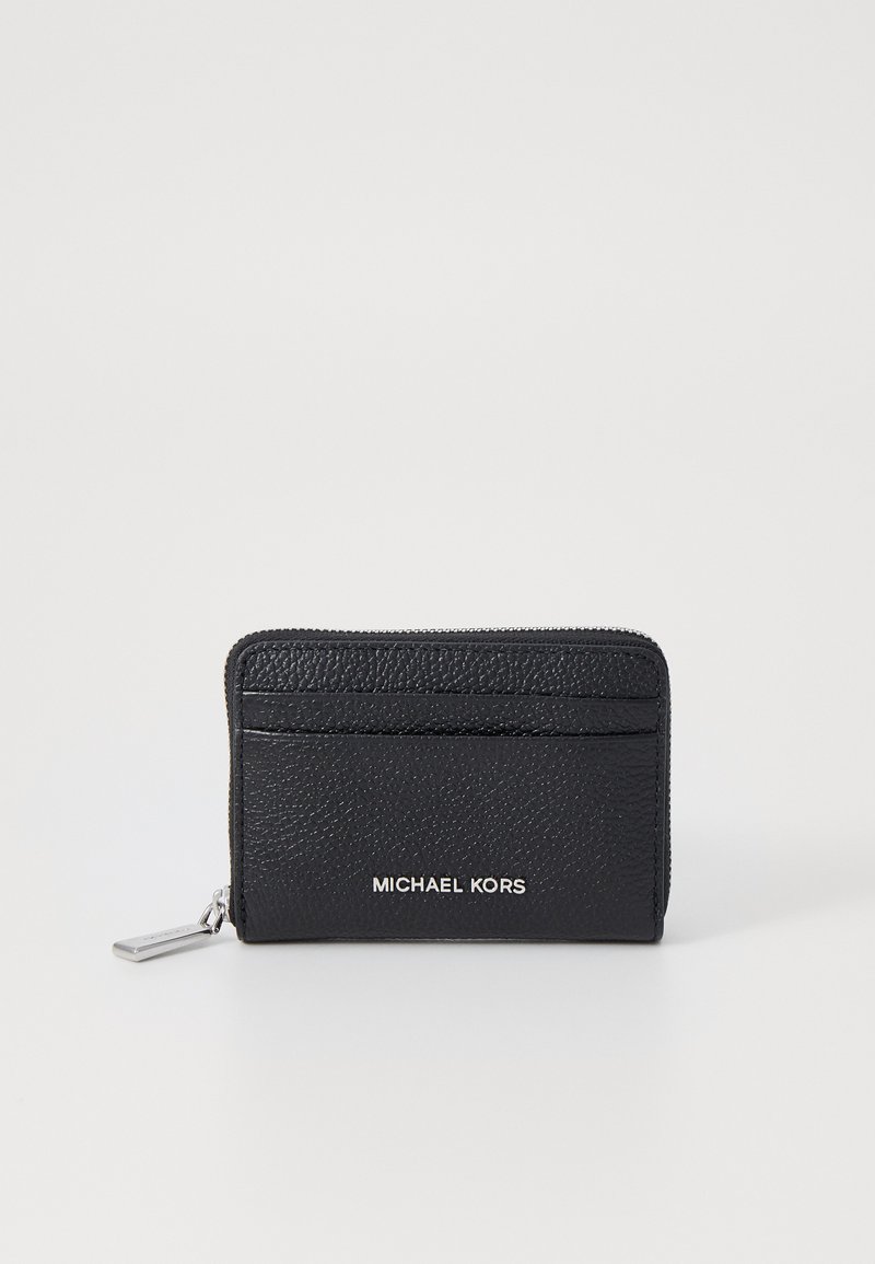 Svart lær lommebok med teksturert overflate, med glidelås og flere kortspor. Sølvfarget "MICHAEL KORS" logo på forsiden.