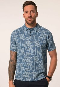 Kortärmad polotröja i blått med palmmönster; tillverkad av tyg med en strukturerad yta. Har treknappars stängning och krage.