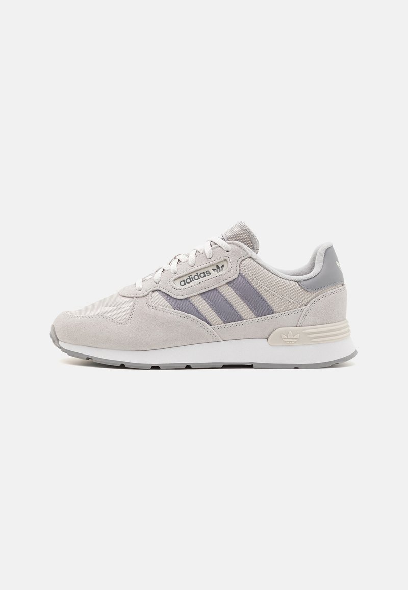 Light gray suede sneakers with mesh accents, three dark gray stripes, and a cushioned white sole. Features a branded tongue and heel.