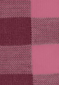 Tissu tricoté avec un motif de damier dans des teintes de rose et de bordeaux, présentant différentes textures et points à travers les sections.
