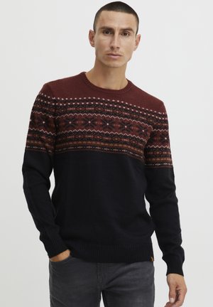 Red and navy knitted sweater featuring a geometric pattern across the chest, ribbed cuffs, and hem. Constructed from soft fabric.