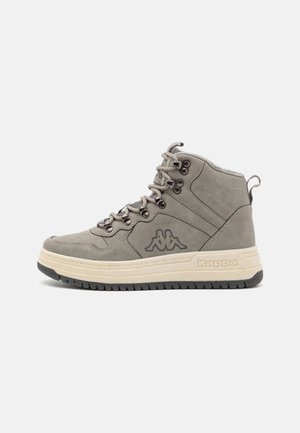 Baskets montantes grises avec semelle épaisse couleur crème, semelle extérieure gris foncé, laçage à l'avant, logo Kappa sur le côté et détails de coutures visibles.