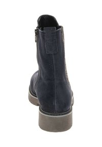 Marine suede enkellaarsje met een gestructureerd achterpaneel, een zijrits en een lage rubberen zool. Gladde afwerking met minimale hardwaredetails.