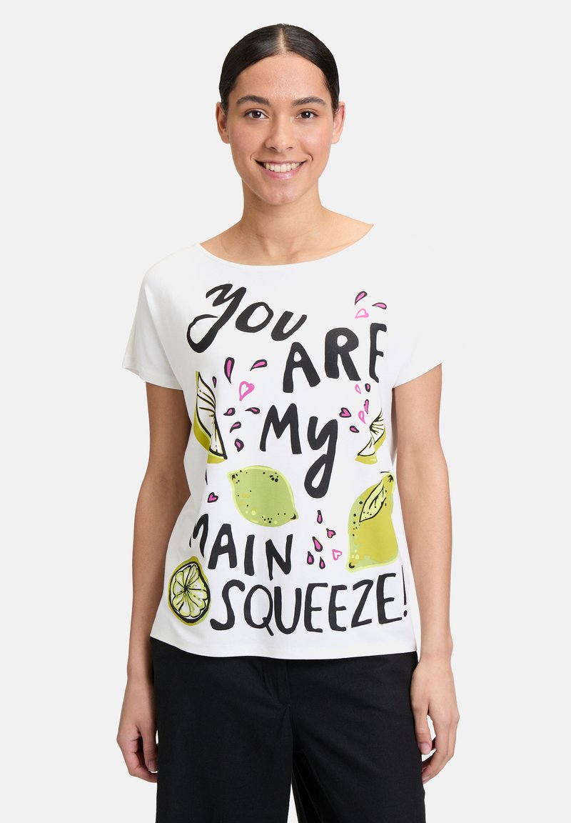 Biała bawełniana koszulka z czarnym napisem "Jesteś moim głównym skarbem!" z zielonymi ilustracjami cytryn i różowymi akcentami.