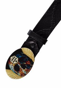 Ceinture en cuir noir avec une surface texturée et une boucle en forme de crâne ovale, colorée, présentant des motifs géométriques et un accent doré.