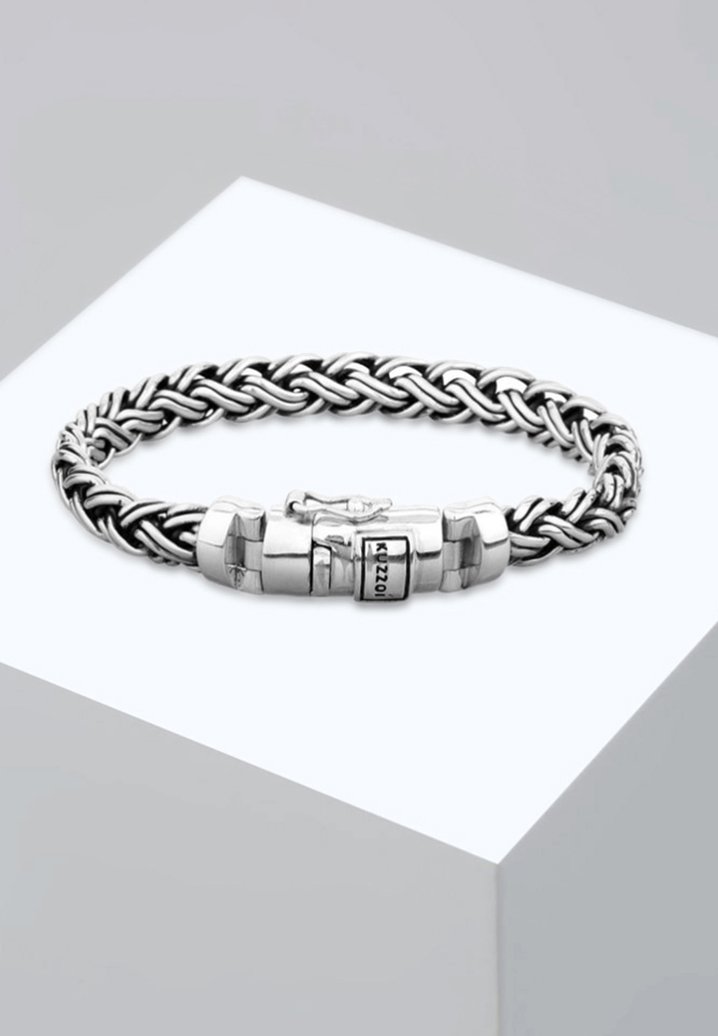 Bracciale in metallo argentato con un design intrecciato, dotato di una chiusura con anelli interlockati e un dettaglio del logo sulla chiusura.
