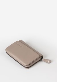 Rectangular wallet in soft, light taupe leather with a zip closure and a small leather tab. Features a textured finish and subtle branding.