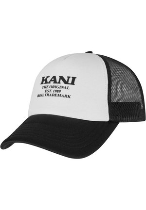 Gorra de camionero con panel frontal blanco y texto negro, visera negra y parte trasera de malla negra. El texto incluye "KANI THE ORIGINAL EST. 1989."