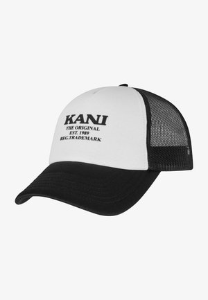 Gorra de camionero con panel frontal blanco y texto negro, visera negra y parte trasera de malla negra. El texto incluye "KANI THE ORIGINAL EST. 1989."