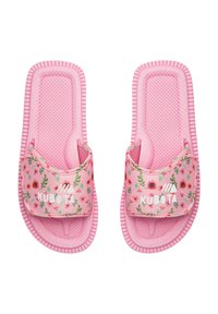 Różowe klapki na zewnątrz z kwiatowym wzorem na paskach, teksturowana wkładka i żebrowana podeszwa. Logo umieszczone na pasku. Miękki, elastyczny materiał.