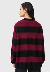 Gruby sweter wykonany na drutach z poziomymi paskami w kolorze burgundowym i czarnym. Luźny krój z długimi rękawami i ribbowym dekoltem.
