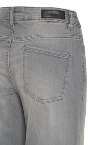 Jeans in denim grigio con vista posteriore e una tasca singola. Il tessuto ha una superficie liscia e un'etichetta nera ICHI è visibile al cinturino.