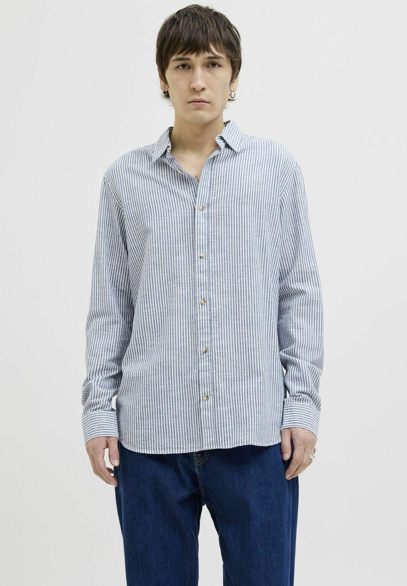 Camisa de botones en rayas azul claro y blanca, de mangas largas, con cuello, botones dorados visibles y puños remangados.