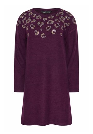 Fioletowa sukienka z długim rękawem, okrągłym dekoltem i zdobieniami przypominającymi cętki lamparta, wykonana z miękkiego materiału o luźnym kroju.