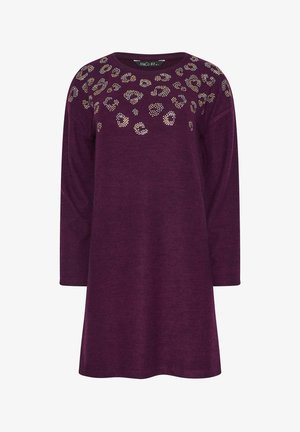 Fioletowa sukienka z długim rękawem, okrągłym dekoltem i zdobieniami przypominającymi cętki lamparta, wykonana z miękkiego materiału o luźnym kroju.
