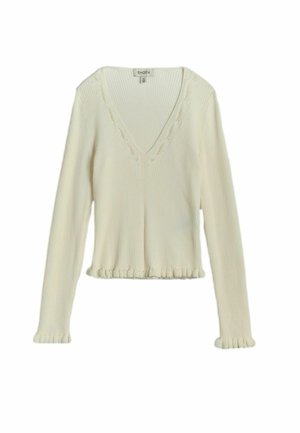 Bluză tricotată cu mâneci lungi, culoarea crem, model cu nervuri, decolteu în formă de V și detalii subtile cu volănașe la manșete și tiv.