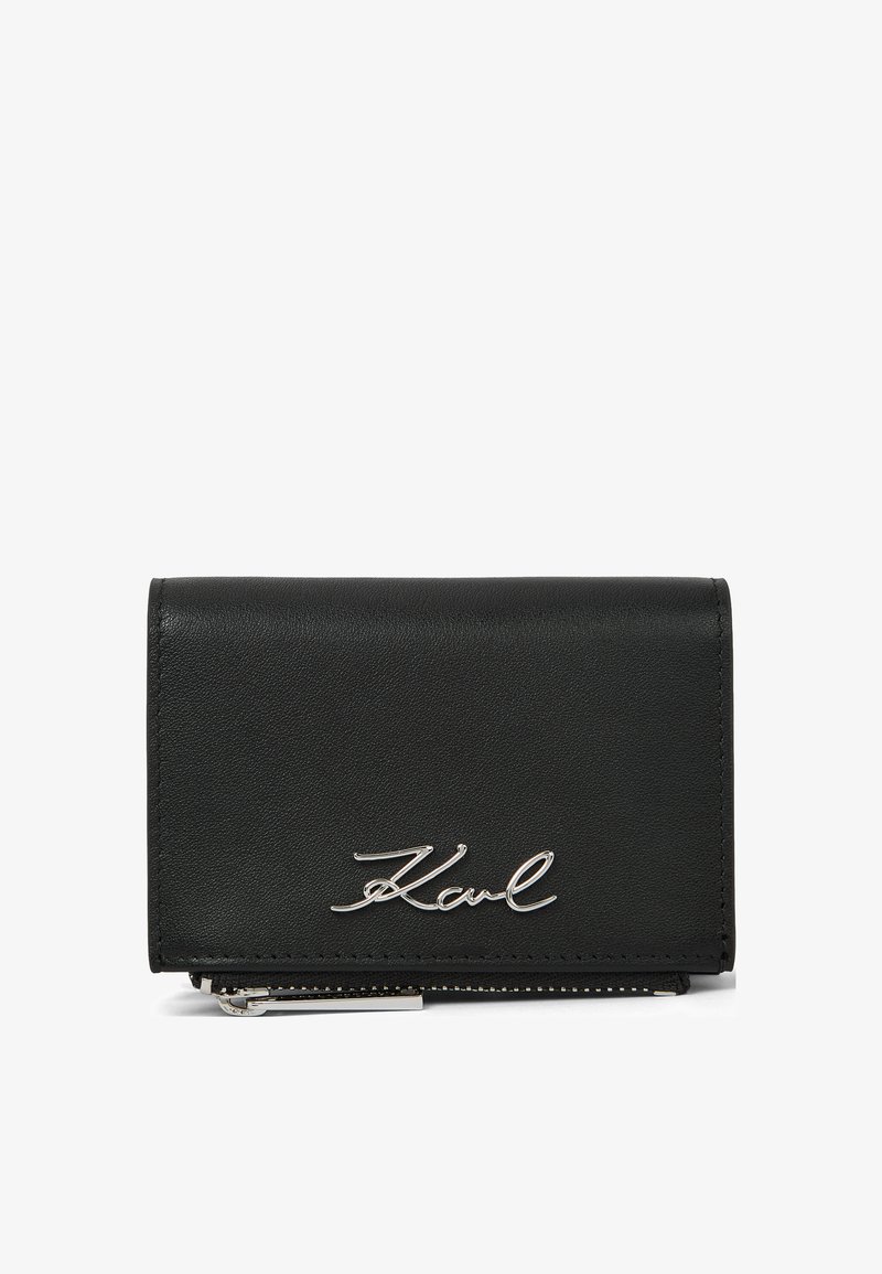Μαύρο δερμάτινο πορτοφόλι με ασημένια υπογραφή "Karl" στο μπροστινό μέρος και ορατό ασημένιο φερμουάρ στο κάτω άκρο.