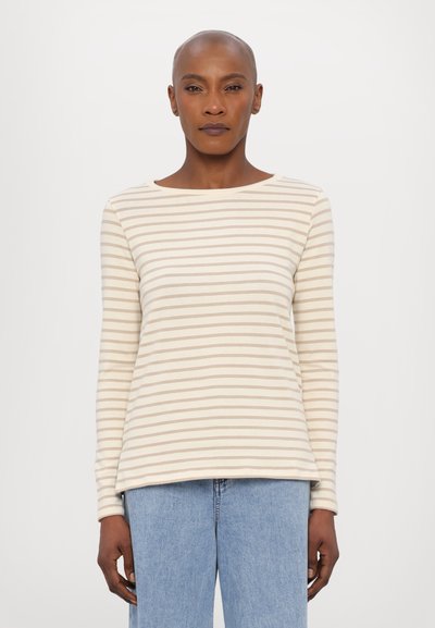 Langærmet stribet bluse i cremefarve med lysebrune striber. Har bådudskæring og en afslappet pasform. Kombinationen med lyseblå denim.