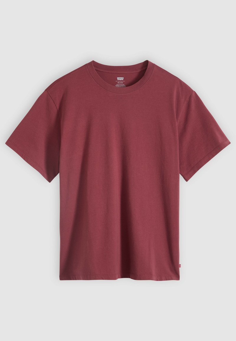 Maglietta semplice a maniche corte con scollo tondo in rosso tenue, mostrata distesa con colletto e maniche visibili su sfondo grigio chiaro.