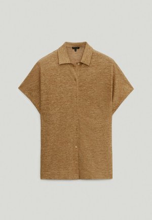 Chemise marron à manches courtes avec boutons et col, en tissu doux et texturé, étalée à plat sur un fond gris clair.