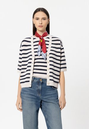Short-sleeve cardigan in cream with navy stripes, featuring a button front. Paired with a striped shirt and high-waisted blue jeans. Red scarf accessory.
