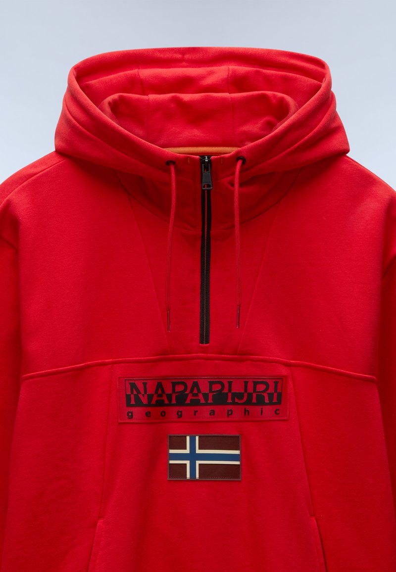 Czerwona polarowa bluza z kapturem z przednim zamkiem, z dużą łatą z logo i detalem flagi Norwegii. Miękka struktura z kieszenią kangurzą.