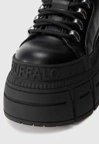 Sapatilha plataforma preta com parte superior em pele, bico redondo, sola de borracha grossa, detalhes em prata e marcação em relevo "BUFFALO" na lateral.