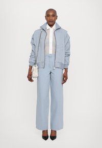 REMAIN COCOON PANTS - Široke nogavice - light blue