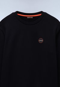 Svart hettegenser med rund hals, med oransje innerkrage og en liten sirkulær logo på forsiden. Glatt tekstur, enkelt design.