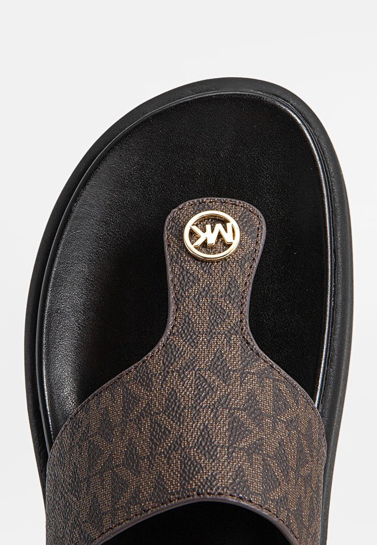 Bruna tryckta slidesandal med texturerad ovandel, svart sula och guldlogotyp som dekoration på remmen. Slät läderfinish.