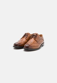 Scarpe dress in pelle marrone con un design classico, dettagli perforati, texture liscia e punta arrotondata con accenti a contrasto.