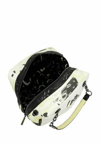 Sac blanc avec des accents noirs, design graphique, fermeture éclair et anse chaîne. Intérieur doublé avec un motif contrastant.