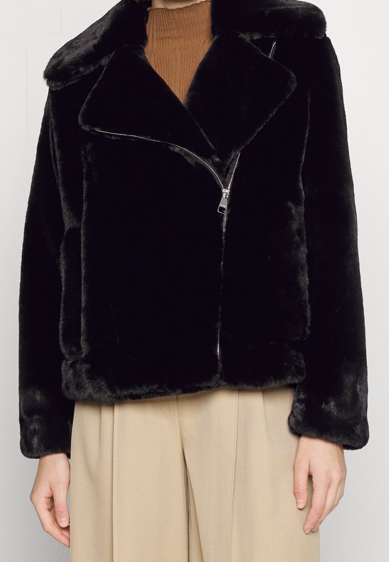 Sort jakke i falsk pels med notched krave, lukkes foran med lynlås og sidelommer. Blød tekstur, kort design og oversized pasform.